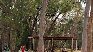 Un parc équipé de tables de pique-nique et d’un espace de repos abrité.