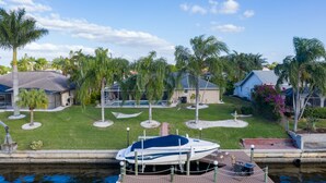 Un bateau était amarré dans une marina, avec une pelouse bien entretenue et des palmiers en arrière-plan.