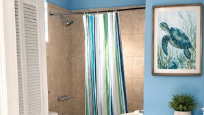 A bathroom with a shower, toilet, and sink. - DIY Vacation Home (Laborie)