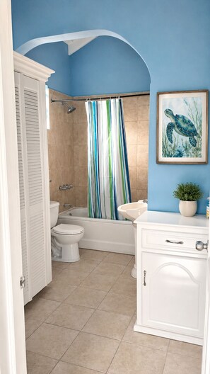 A bathroom with a shower, toilet, and sink.
