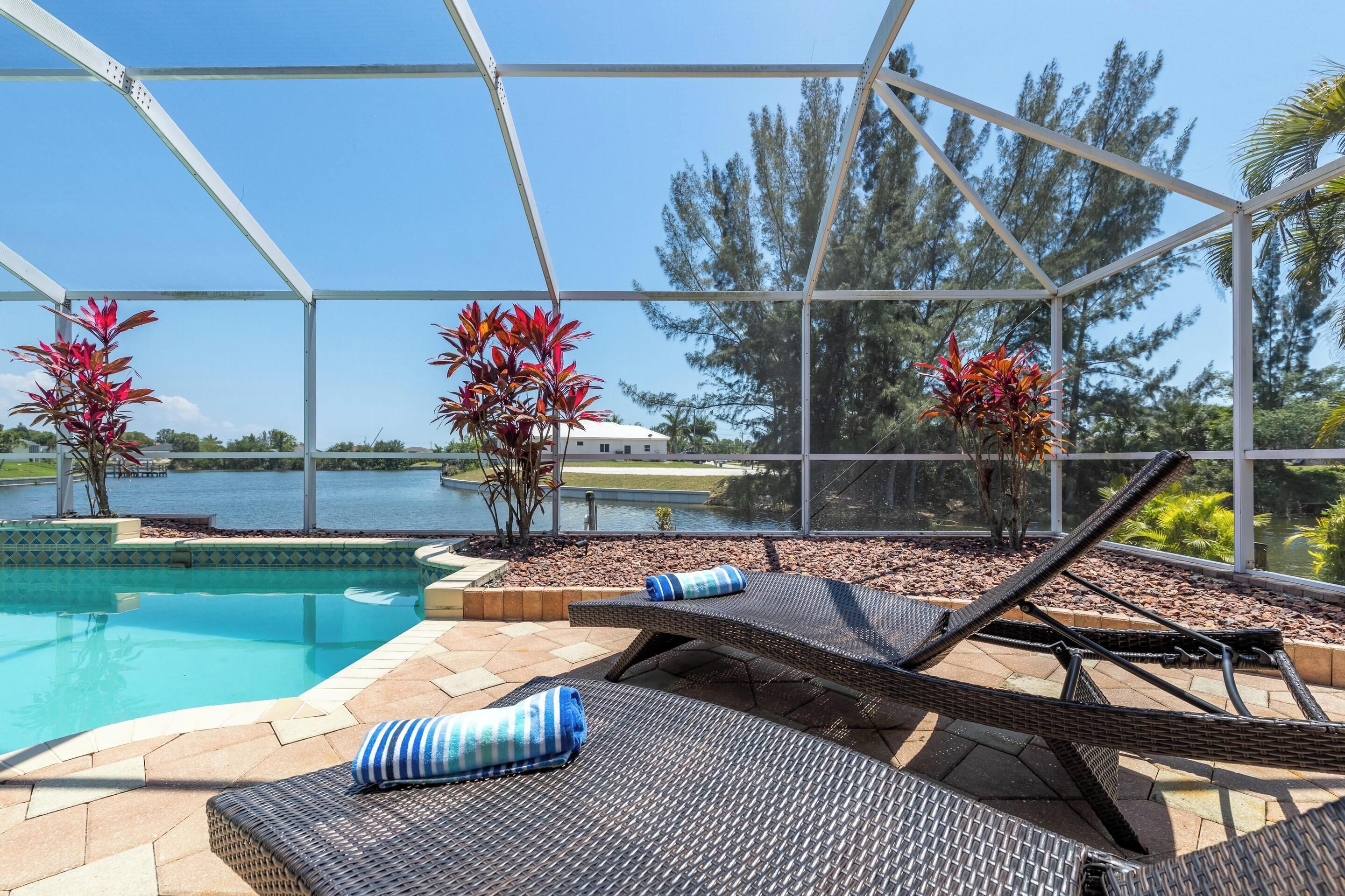 A pool area with lounge chairs and potted plants.