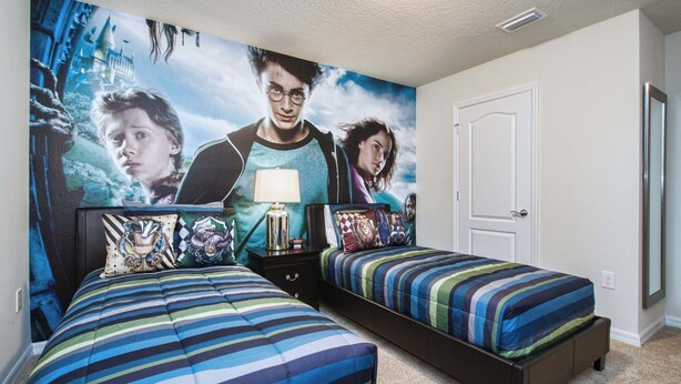 Una camera da letto con due letti, un comodino e un affresco sulla parete.
