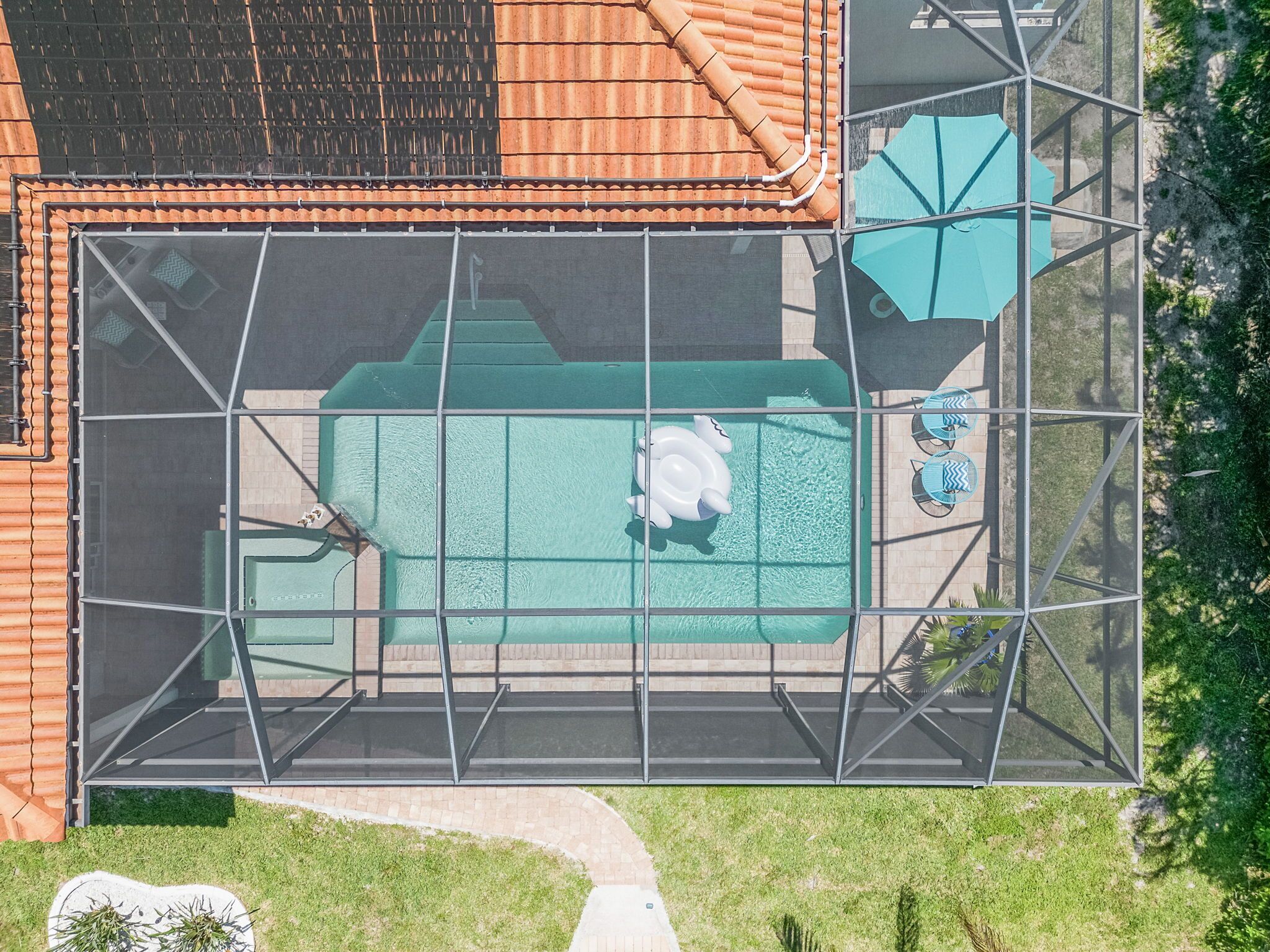 Ein Pool auf dem Dach mit einer Glaskonstruktion, umgeben von einem Metallrahmen.