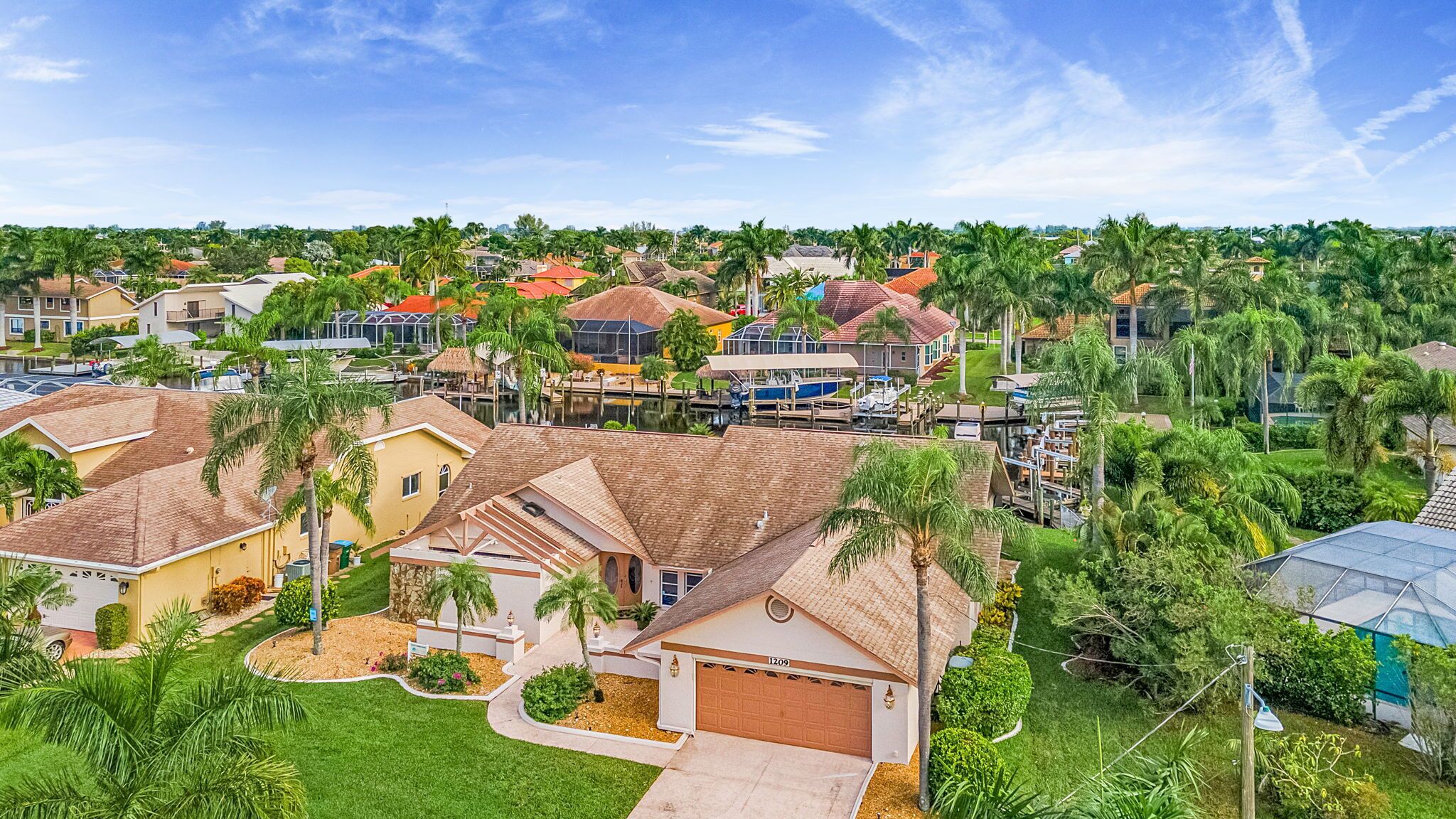 Un barrio residencial con casas, palmeras y un puerto deportivo.