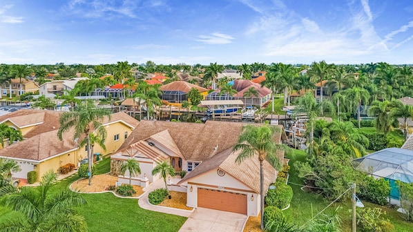 A residential area with houses, palm trees, and a marina.