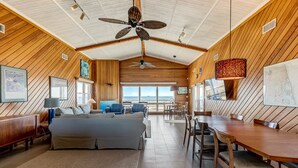 Une pièce spacieuse avec un grand lit, une table à manger et un ventilateur de plafond.