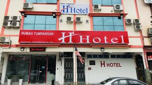 A hotel with a prominent red and white facade, large windows, and multiple air conditioning units. - H-Hotel (Johor Bahru)