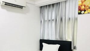 A neatly made bed with white linens in a room with a black headboard. - H-Hotel (Johor Bahru)