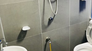 A bathroom with a toilet, sink, and shower. - H-Hotel (Johor Bahru)