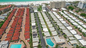 An aerial view of a resort with multiple buildings, a swimming pool, and a beach in the background. - Island House Beach Resort V8 (Siesta Key)