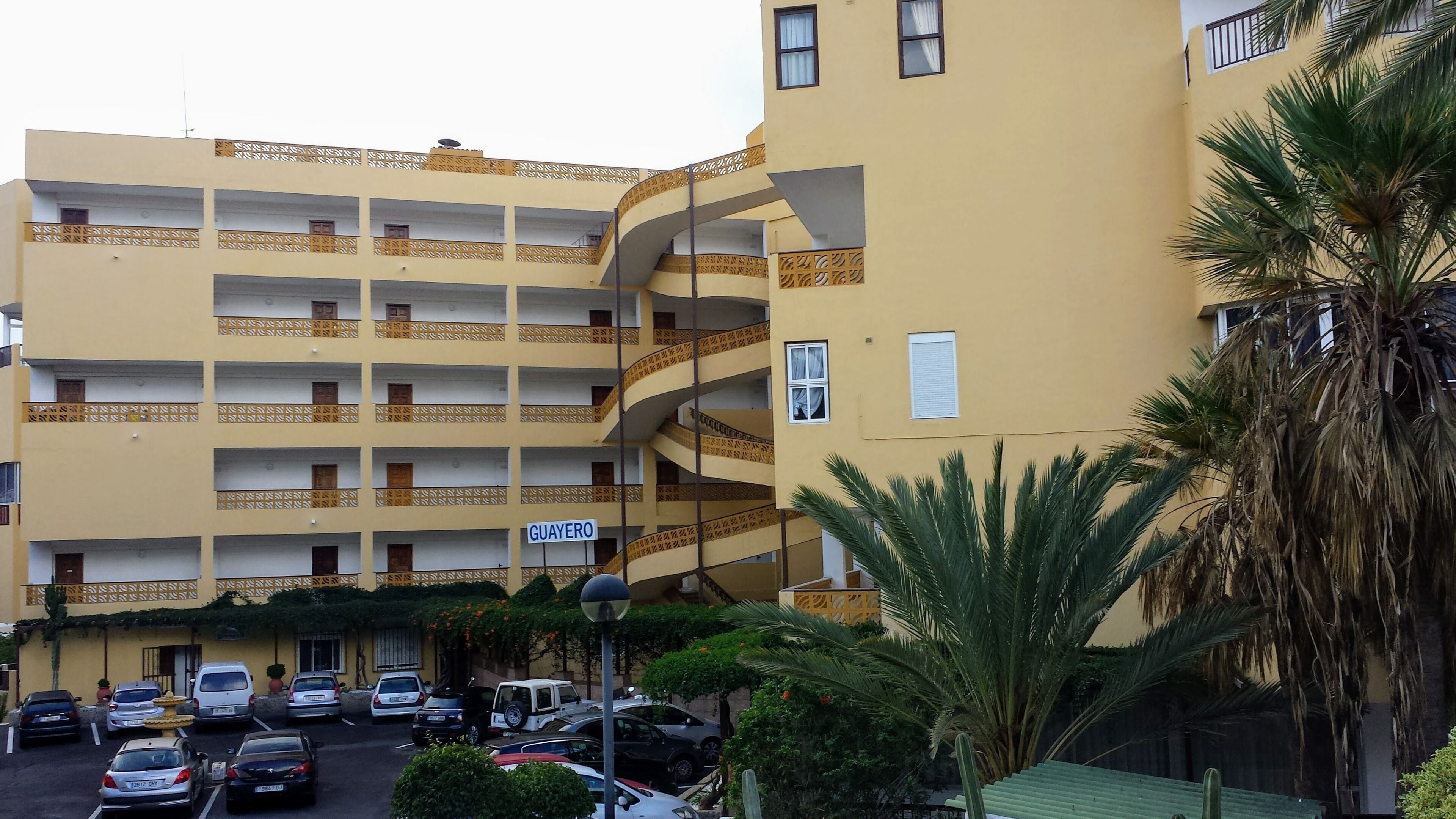 Un hôtel à plusieurs étages, doté d’une façade jaune, de nombreux balcons et d’une enseigne indiquant le nom « GUAYERO ».