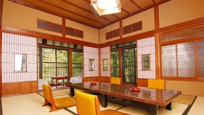 Una habitación japonesa tradicional con suelo de tatami, una mesa baja y puertas correderas.