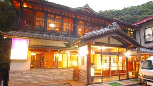 Un edificio japonés tradicional con fachada de madera, ventanas grandes y techo de tejas.