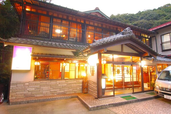 Un edificio japonés tradicional con fachada de madera, ventanas grandes y techo de tejas.