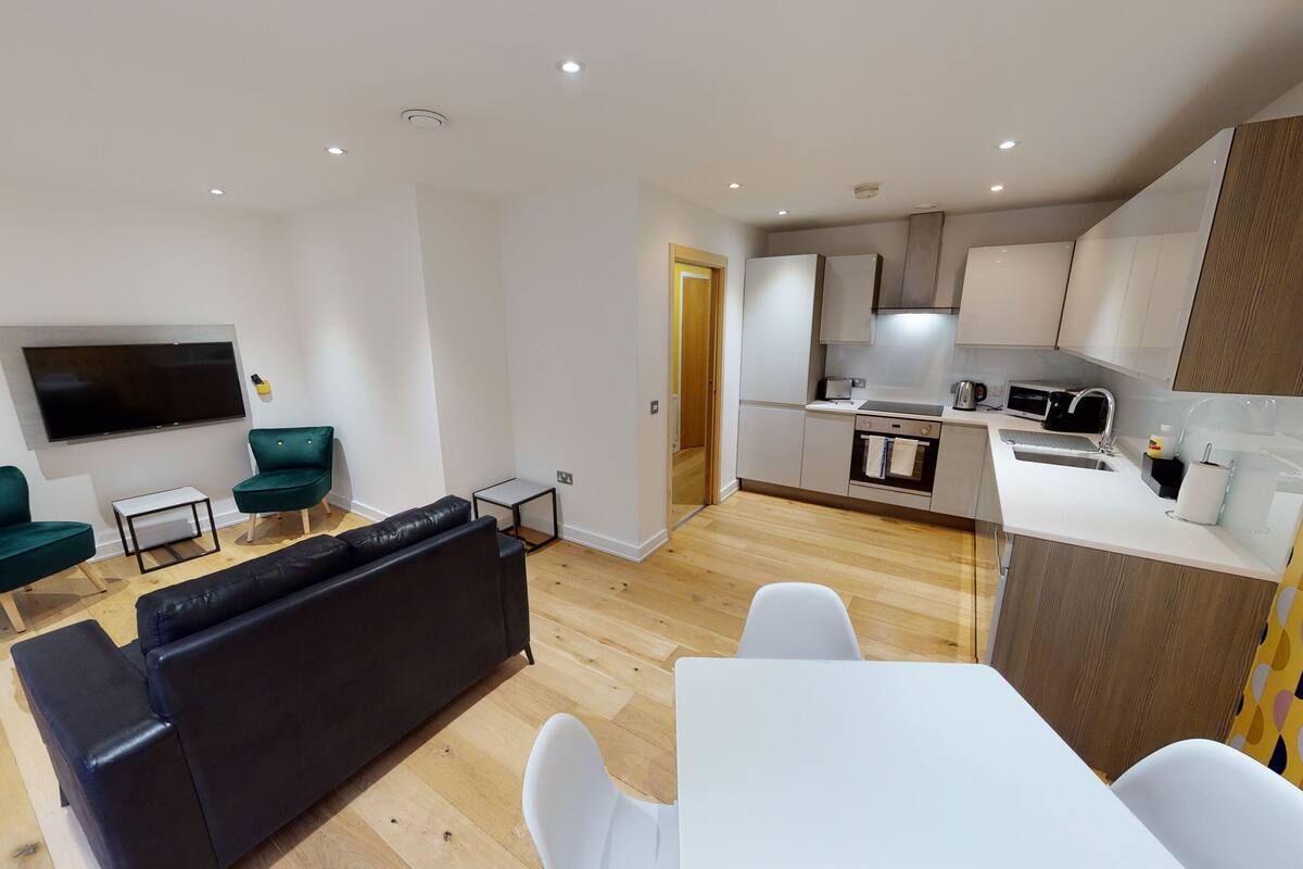 A modern apartment with a living room, dining area, and kitchen.