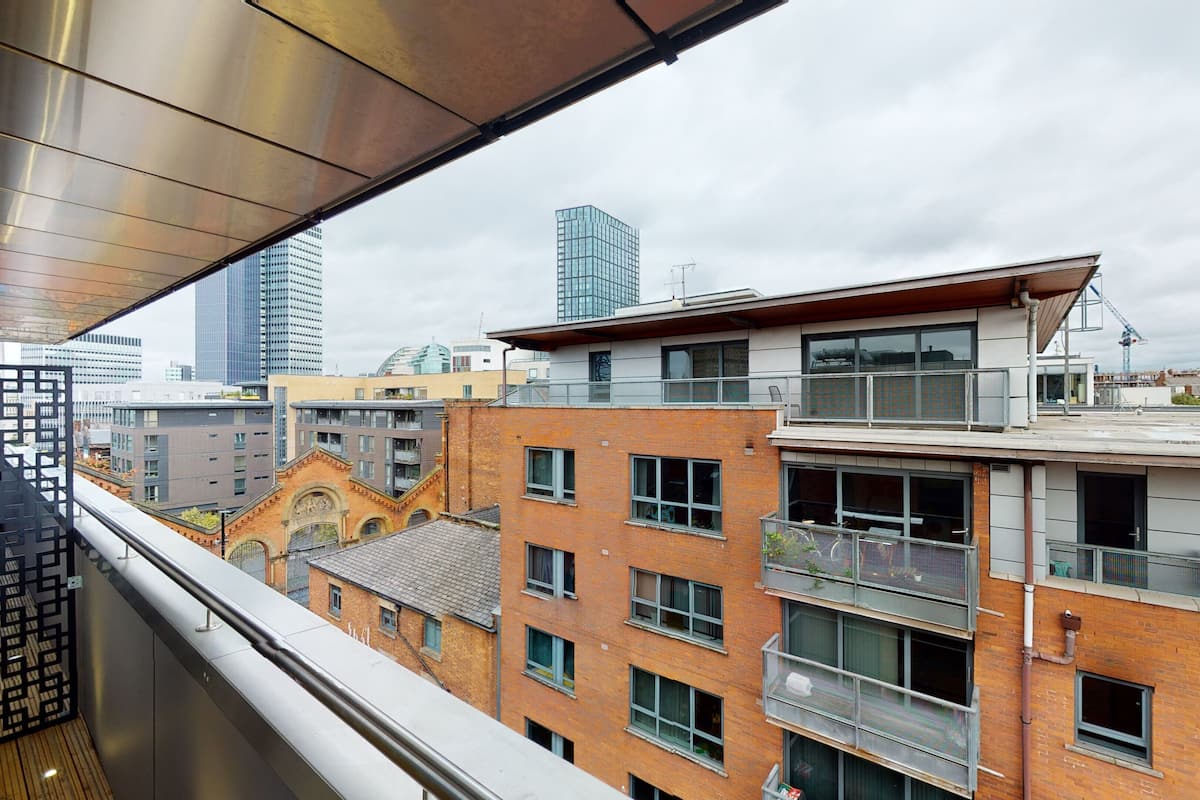 A high-rise building with multiple balconies, large windows, and a view of the cityscape.