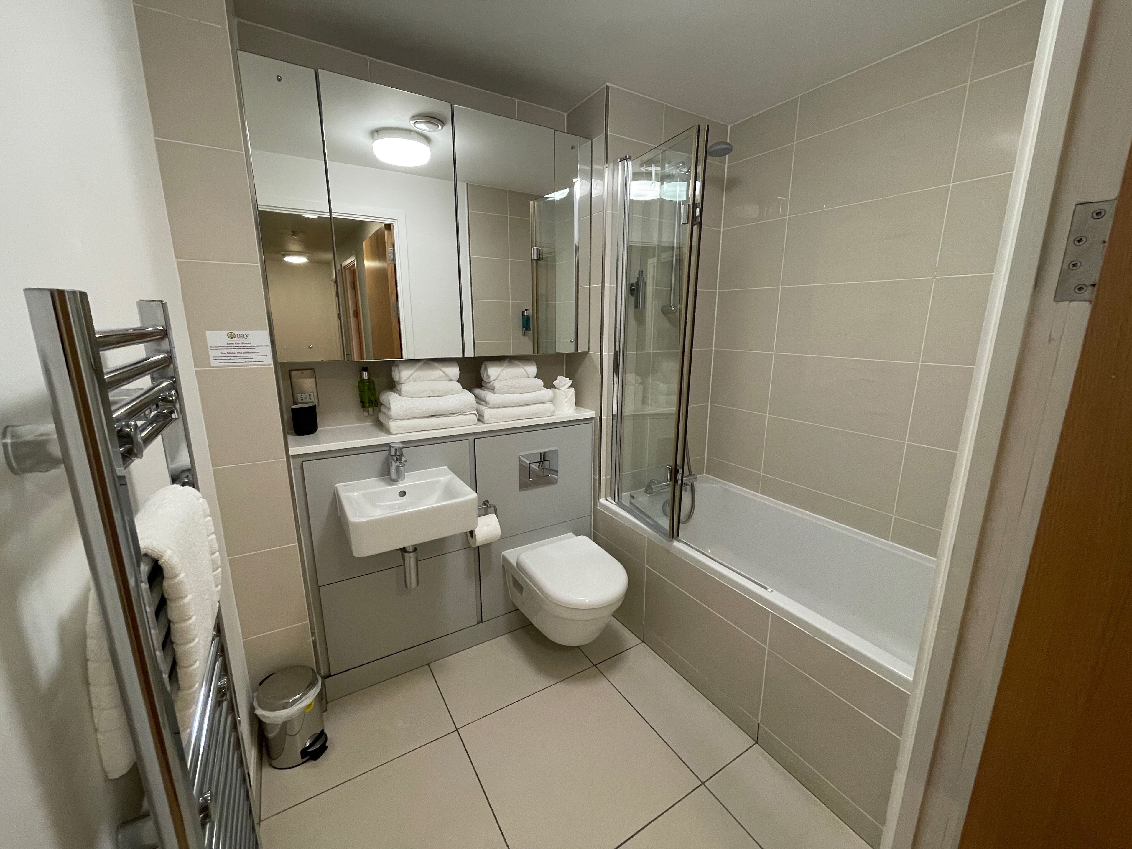 A modern bathroom with a glass shower enclosure, a white sink, and a toilet.