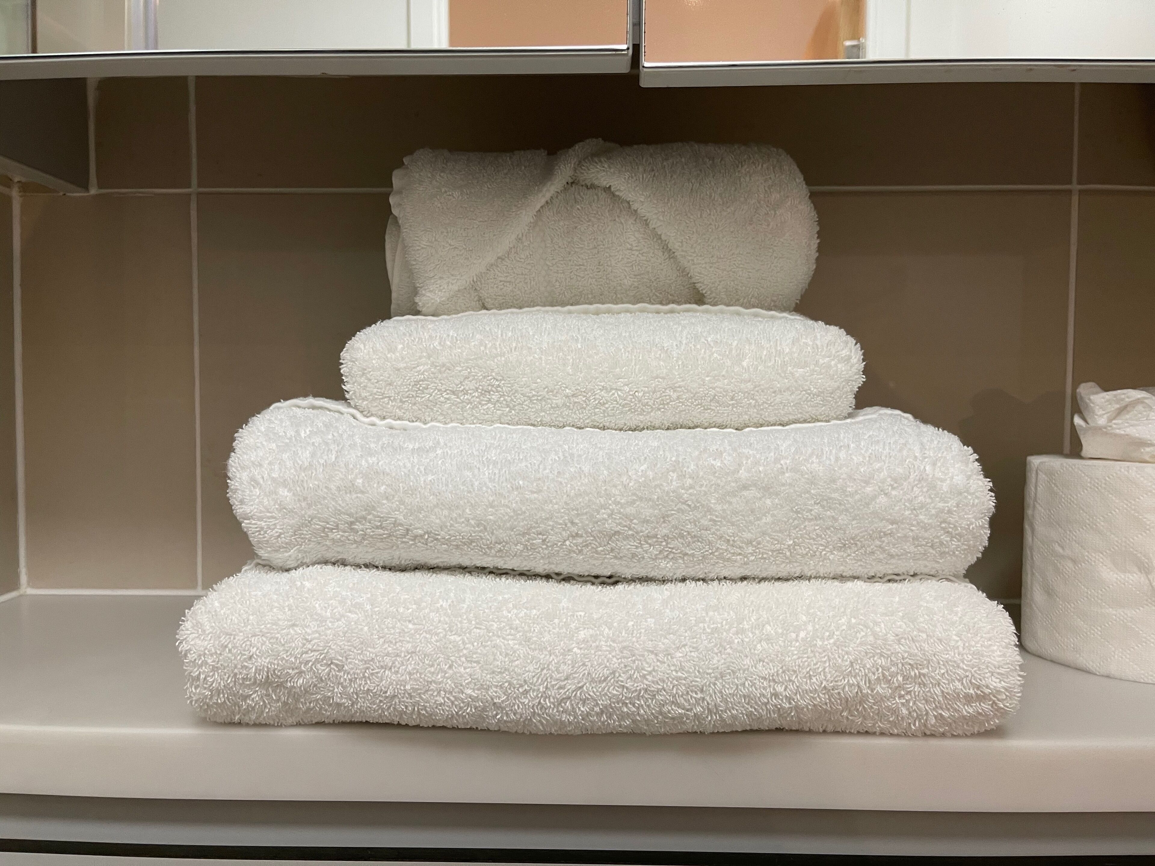 A stack of white towels on a bathroom counter.