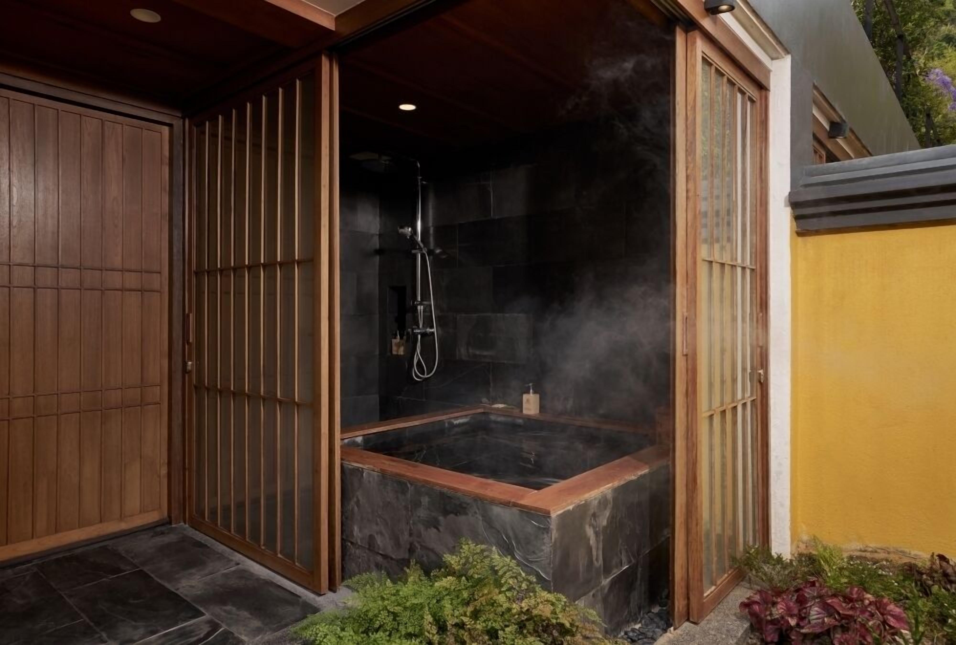 A spa area with a hot tub, steam, and a wooden door.