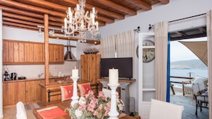 Una cocina acogedora con armarios de madera, una araña y una zona de comedor con una mesa preparada para dos.