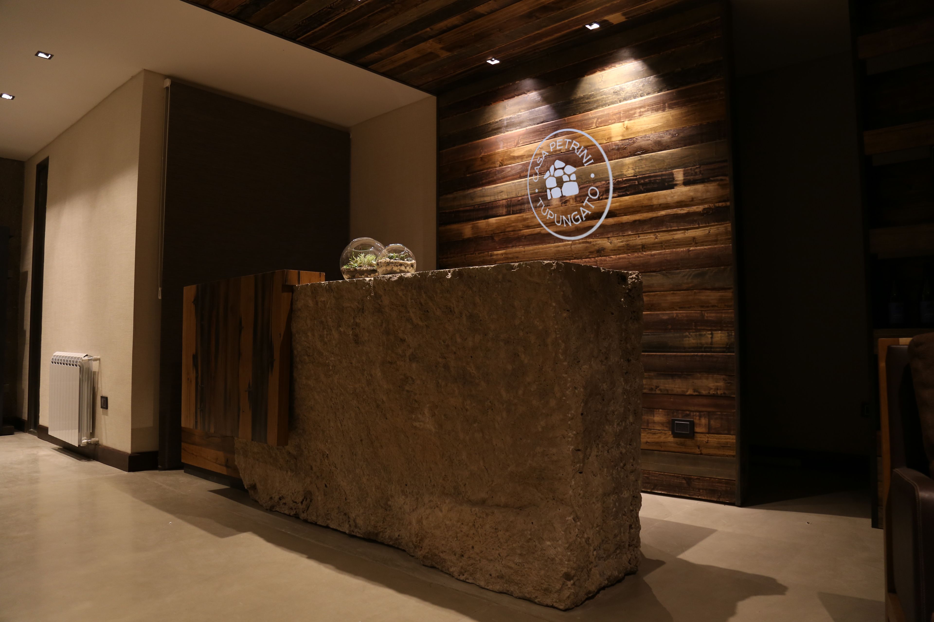 A reception area with a wooden wall and a stone counter.