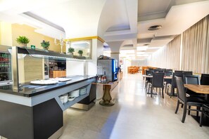 A modern restaurant with a bar area, seating, and a buffet counter. - Albatros (CALENZANO)