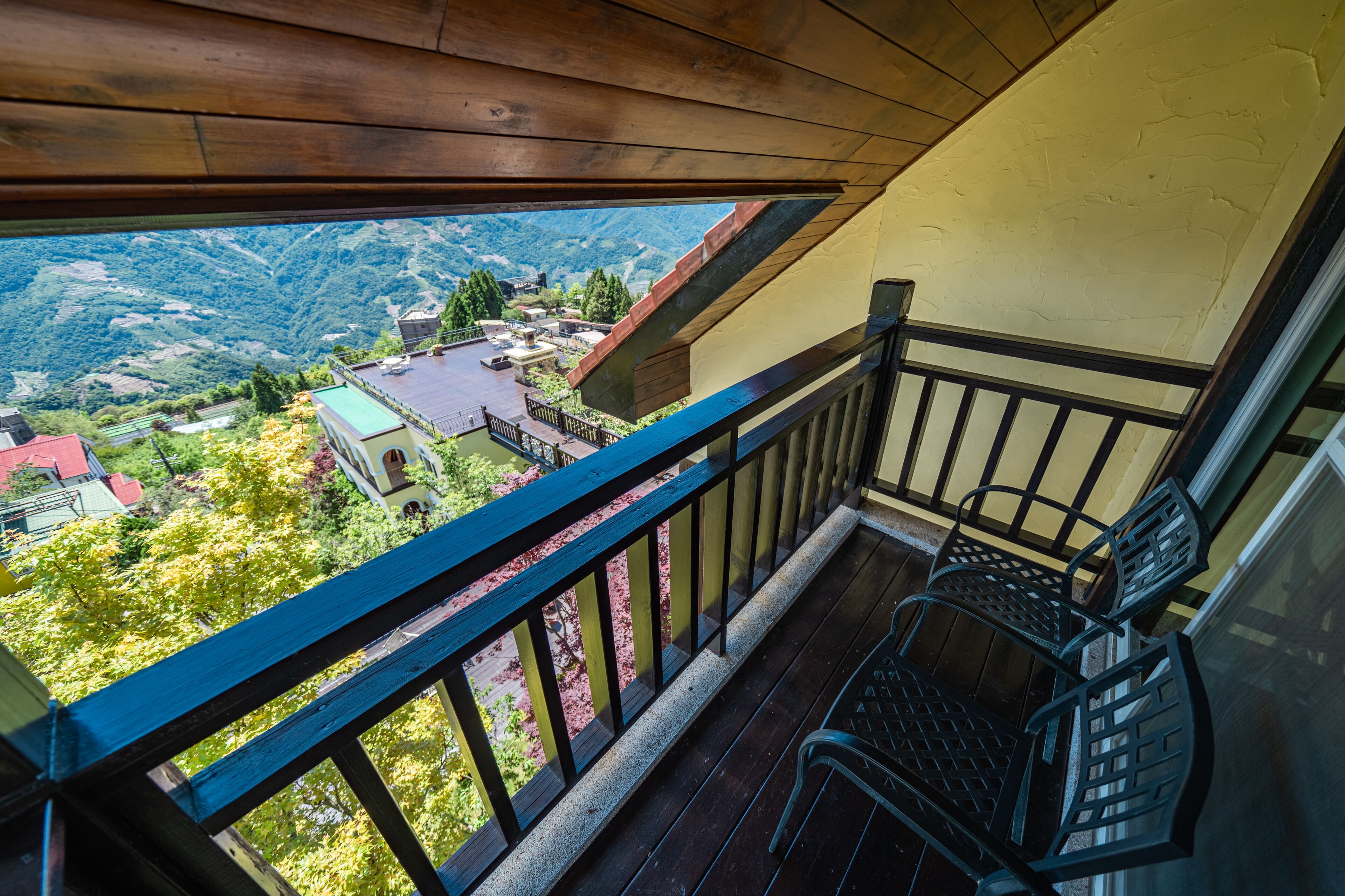 A balcony with a view of a valley and houses.