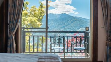 A room with a large window overlooking a mountainous landscape.