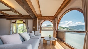 Una habitación con un ventanal grande, un sofá y una pequeña mesa.
