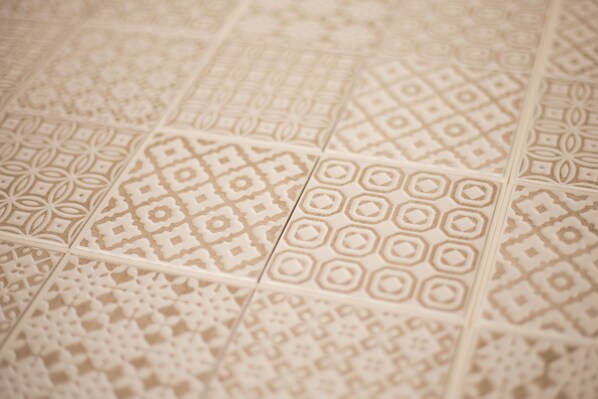 A close-up of a patterned tile floor with various geometric designs.