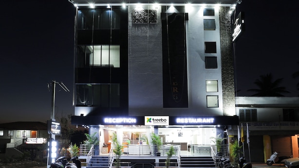 A multi-story building with a reception area and a restaurant. - Treebo Sandpipers Kushalnagar (Somvarpet)