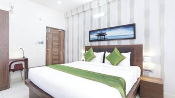 A hotel room with a bed, a desk, and a chair.