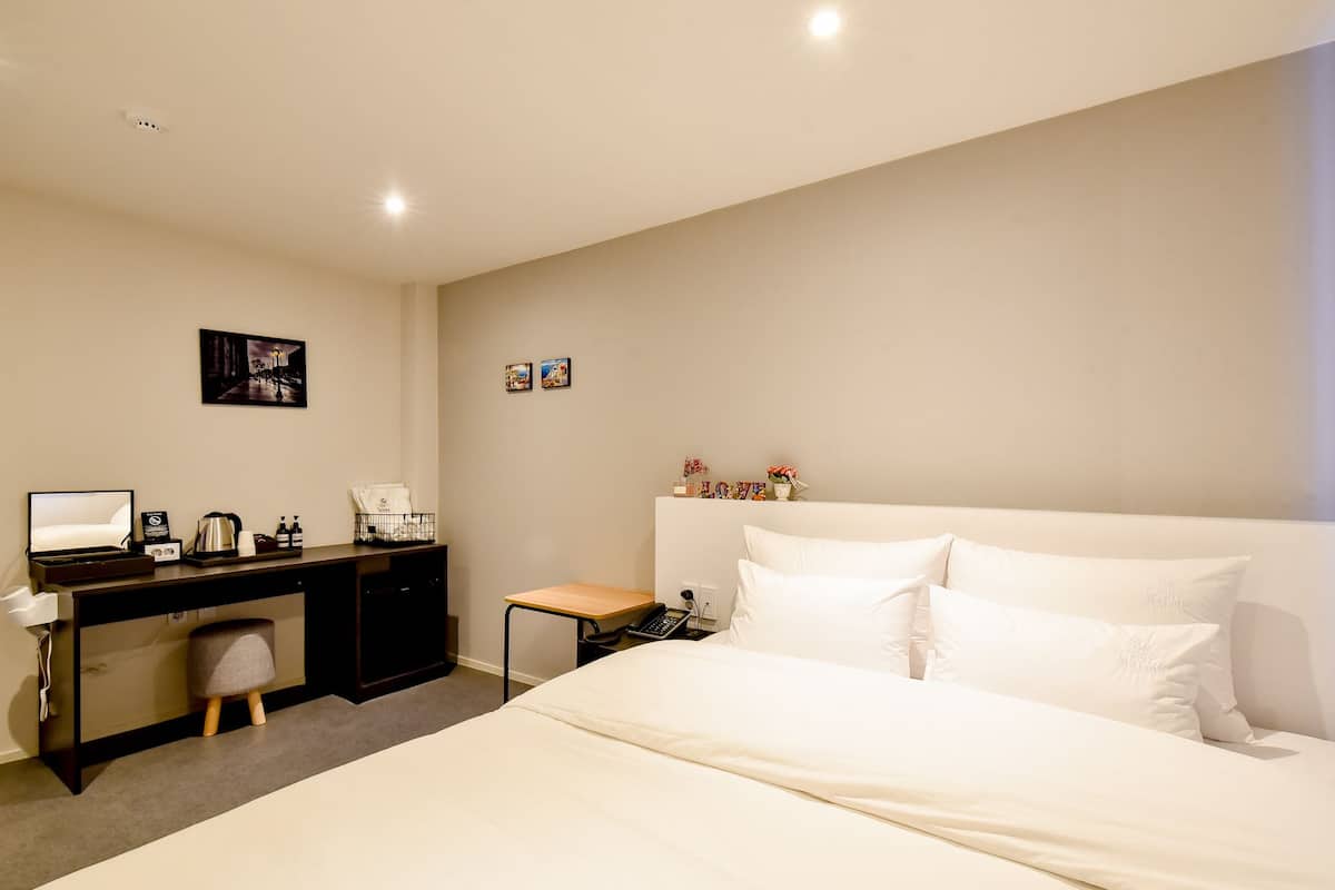 Ein Hotelzimmer mit Bett, Schreibtisch und Stuhl.