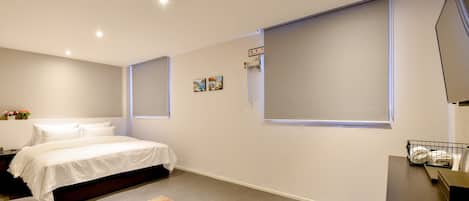 Escritorio, cortinas blackout y tabla de planchar con plancha