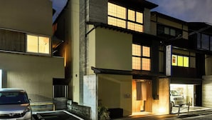A multi-story building with illuminated windows, a visible entrance, and a signboard.