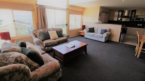 A living room with a sofa set, a coffee table, and a white couch.