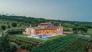 A two-story stone house with a swimming pool, surrounded by well-maintained gardens and a hilly landscape. - Gorgeous home in Krnica with sauna (Krnica)
