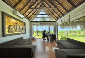 Quarto com teto alto, janela grande e vista para o exterior.