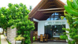 A modern house with a glass door entrance, surrounded by lush greenery and a well-maintained lawn. - Blue Whale beach boutique Resort (Kandakuliya)