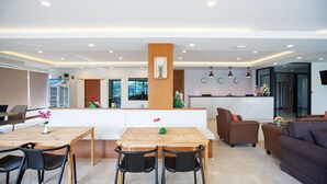 Una sala moderna con una mesa de comedor de madera, sillas negras y un sofá marrón.