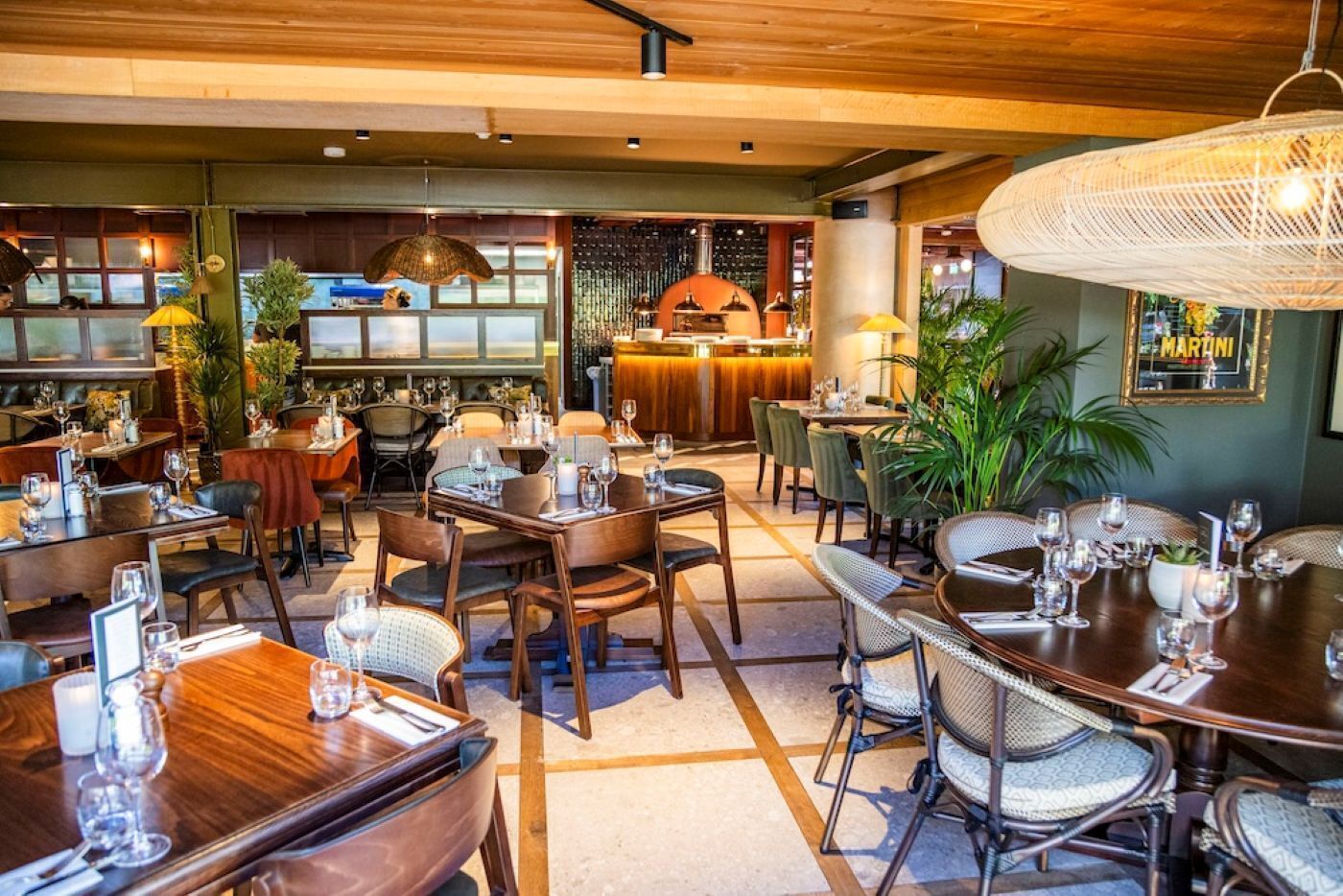 A restaurant with wooden tables, chairs, and hanging lights.
