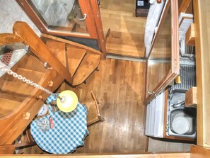A compact kitchen with wooden cabinets, a sink, and a small table with a checkered cloth.