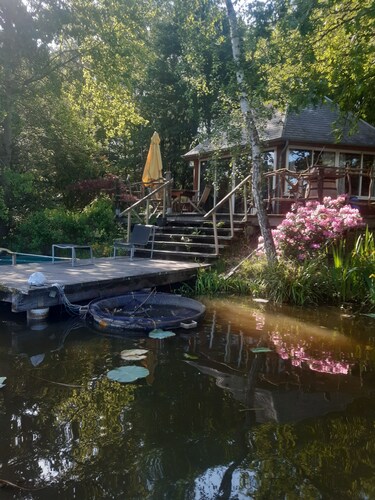 Chalet am Rande eines Teiches in einem Ort, wo die Natur erhalten ist. Angeln, Kanus