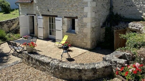 Un bâtiment en pierre doté d’un patio, d’un espace extérieur aménagé pour s’asseoir et d’un petit jardin.