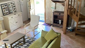 Un salon comprenant un canapé, une table basse, un fauteuil et un meuble.