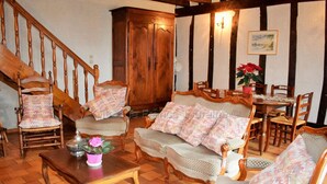 Un salon traditionnel avec un escalier, des meubles en bois et un coin repas.