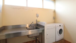 A compact laundry area with a sink, washing machine, and a window above. - Semi-Detached Home in Omonville-la-Rogue with Parking and Pets Allowed (Omonville-la-Rogue)