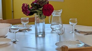 A round dining table with white plates, clear glasses, and a pitcher of water. - Semi-Detached Home in Omonville-la-Rogue with Parking and Pets Allowed (Omonville-la-Rogue)