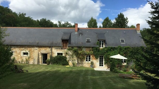 A stone house with a sloped roof, a small front porch, and a well-maintained lawn. - Charming cottage in Chinon forest with private garden (Saint-Benoît-la-Forêt)