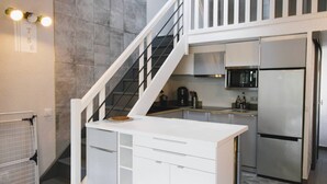 A compact kitchen with a white countertop, stainless steel appliances, and a staircase with a black railing. - GASSIN / FONT-MOURIER: 1/2-BEDROOM MAZET IN ESTATE WITH POOL AND TENNIS (GASSIN)